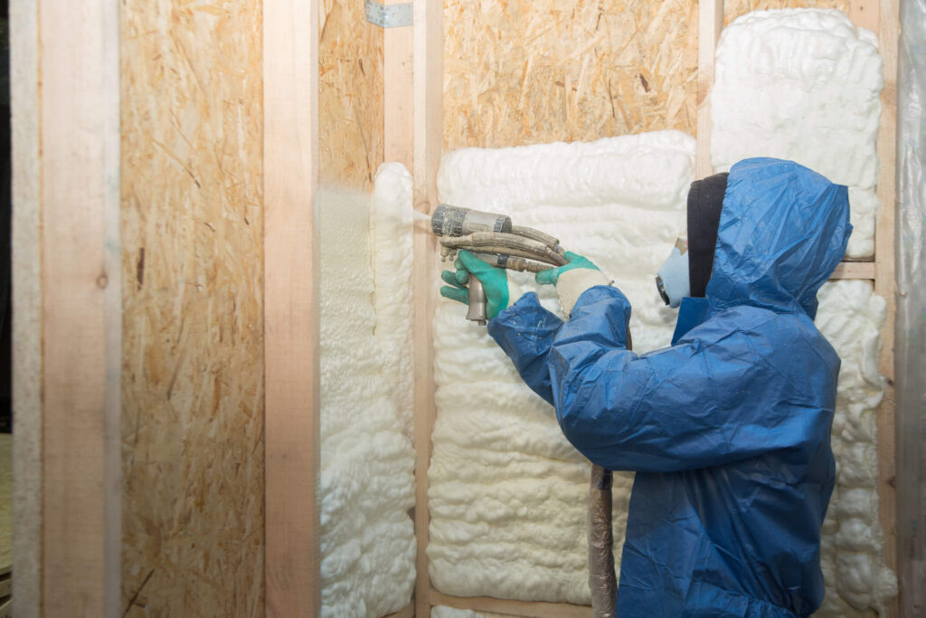 The worker insulates the walls of the house with foam for sound insulation and heat